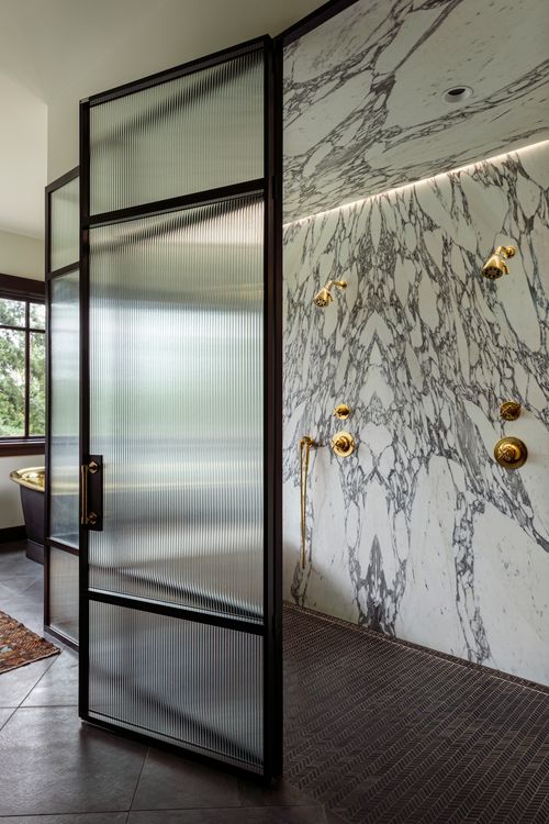 Spa-inspired bathroom with rainfall shower and brass fixtures